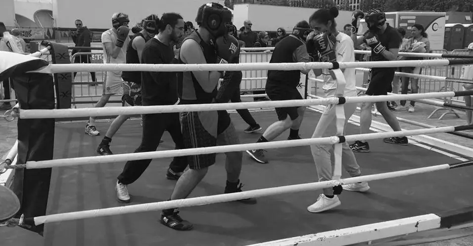 Un groupe s’entraîne autour d’un ring en plein air
